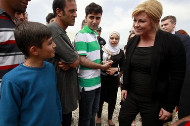A horvát elnöknő, iraki és szíriai menekültekkel beszélget a gyevgyelijai tranzitközpontban (Fotó: Beta/AP)