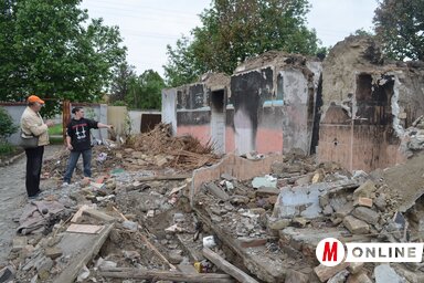 Vajda László (jobbról) megmutatja a leégett házat (Lakatos János felvétele)