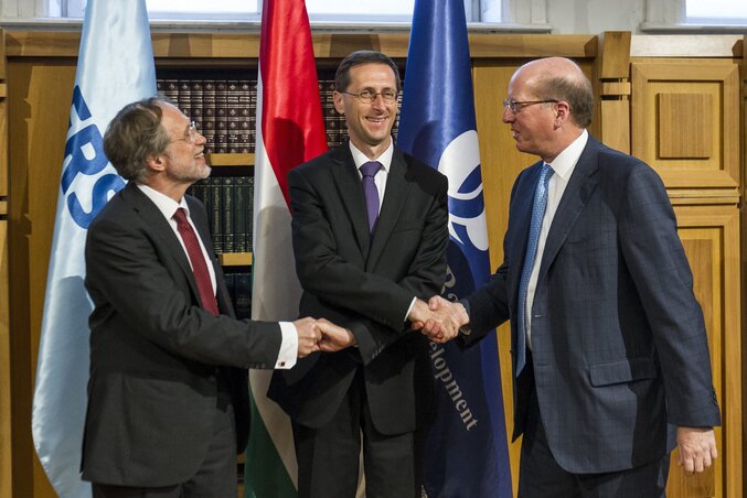 Kézfogás a szerződés aláírása után: Friedrich Rödler, Varga Mihály és Philip Bennett (Fotó: MTI)