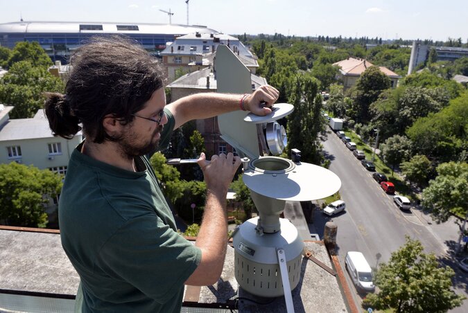 Az Országos Közegészségügyi Központ Aerobiológiai Monitorozási Hálózatának munkatársa méréshez kiveszi a pollendobot az intézmény tetején lévő pollencsapdából (Fotó: MTI)