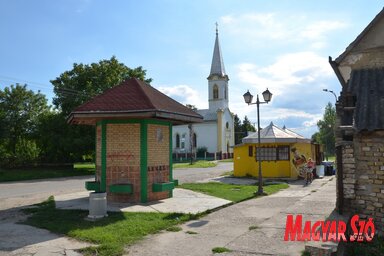 Az ökokút, háttérben a római katolikus templommal