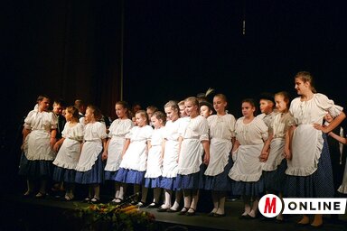 Színpadon a házigazda Feketics M. E. néptáncosai