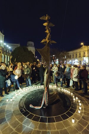 Megemlékezők mécsest gyújtanak az áldozatok és hősök tiszteletére emelt emlékműnél Debrecenben (Fotó: MTI)