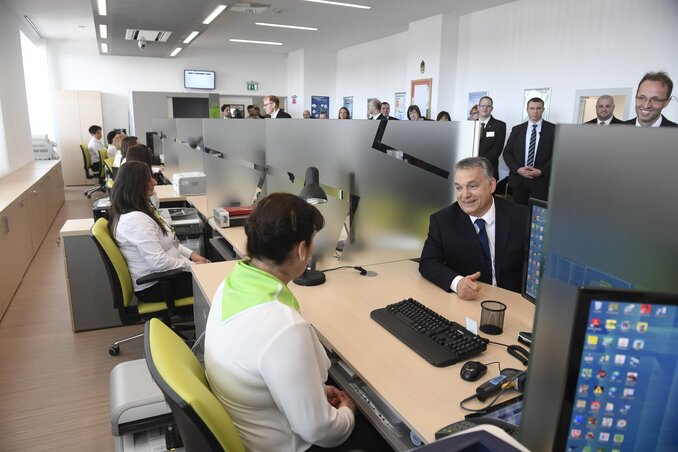 A miniszterelnök a Szigetszentmiklósi Igazgatási Központ egyik munkatársával beszélget (Fotó: MTI)