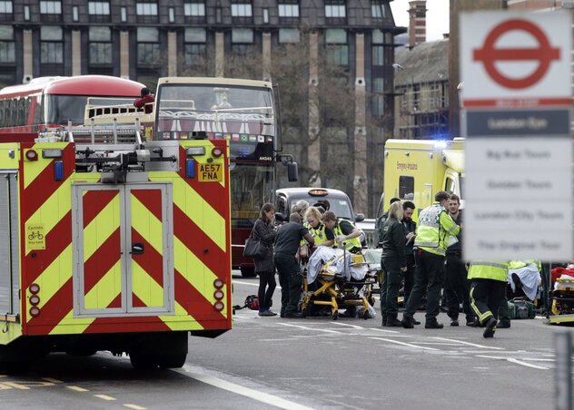 Mentősök egy sebesültet részesítenek elsősegélyben a brit parlament épületénél (Fotó: MTI/AP/Matt Dunham)