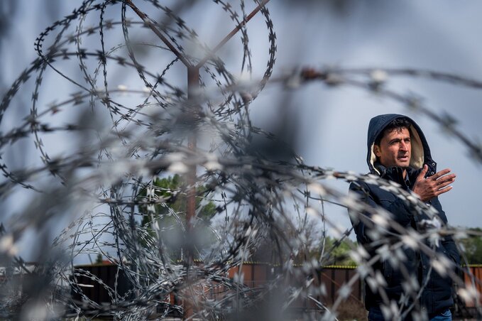 Újságíróval beszélget egy bevándorló a magyar–szerb határon (Fotó: MTI)
