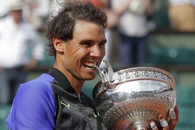 Spain's Rafael Nadal bites the trophy after defeating Switzerland's Stan Wawrinka in their final match of the French Open tennis tournament at the Roland Garros stadium, Sunday, June 11, 2017 in Paris. Nadal has won his record 10th French Open title, beat
