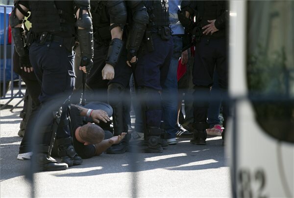 Az esti román-magyar világbajnoki selejtező labdarúgó mérkőzésre különvonattal érkezett magyar szurkolók egyike fekszik a földön román csendőrök gyűrűjében a bukaresti Északi Pályaudvaron (MTI Fotó: Baranyi Ildikó)