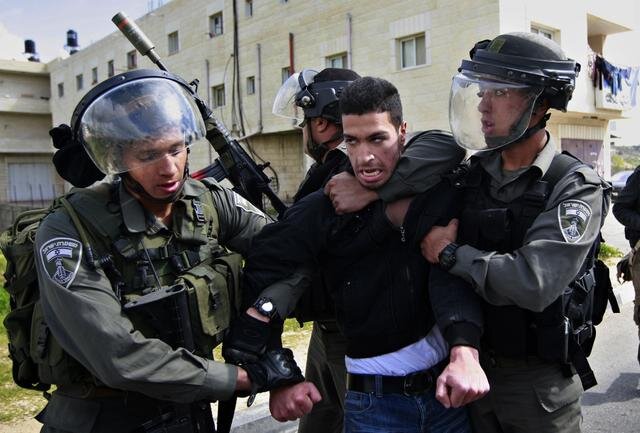Izraeli katonák őrizetbe vesznek egy palesztint, aki egy Rámalláh melletti faluban tiltakozott a ciszjordániai biztonsági fal felépítése ellen (korábbi felvétel) (Fotó: Beta/AP)