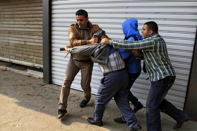 Civil ruhás rendőrök őrizetbe veszik Mohamed Murszi egyik hívét Kairóban (Fotó: Beta/AP)