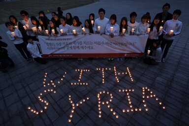 A háború gyermekáldozataival való együttérzésük jeleként Szöulban dél-koreai egyetemisták gyertyákkal és egy óriásmolinóval emlékeztek meg a szíriai polgárháború harmadik éves évfordulójáról (Fotó: Beta/AP)