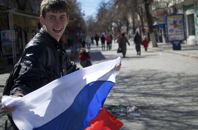 Orosz zászlót lobogtató fiatal a szimferopoli utcán (Fotó: Beta/AP)