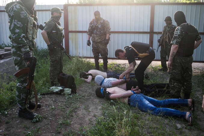 Oroszbarát fegyveresek Kramatorszkban három kémkedéssel gyanúsított ukránt kötöznek meg (Fotó: Beta/AP)