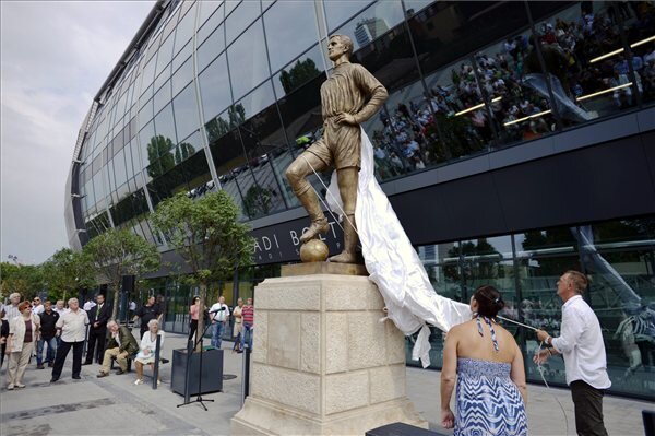 Albert Magdolna (háttal) és ifj. Albert Flórián (jobbról) leleplezik édesapjuk, az egyetlen magyar aranycipős labdarúgó, Albert Flórián szobrát a Ferencváros új stadionja, a Groupama Aréna előtt