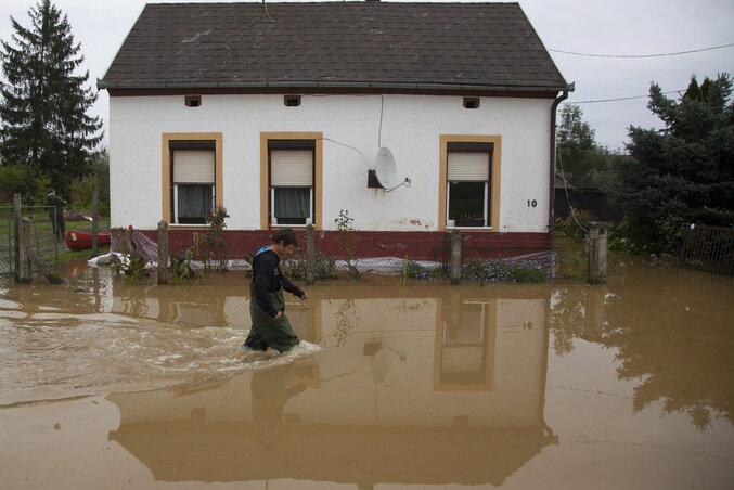 Egy férfi gyalogol a vízben a csákánydoroszlói Dózsaligetben, ahonnan tizennyolc embert kellett ideiglenesen kiköltöztetni otthonából a Rába és a Vörös-patak áradása miatt (Fotó:  MTI)