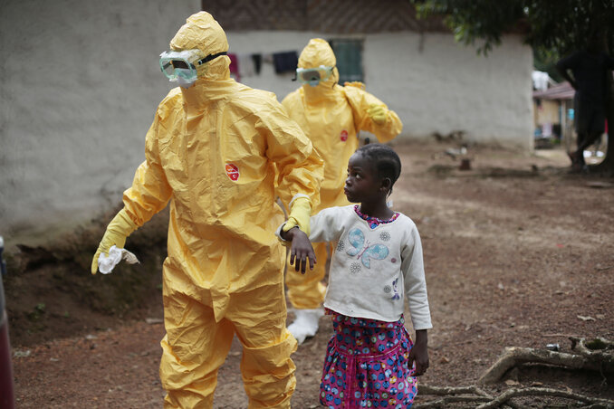 Ebolafertőzés gyanújával orvoshoz kísérnek egy kislányt egy libériai faluban (Fotó: Beta/AP)