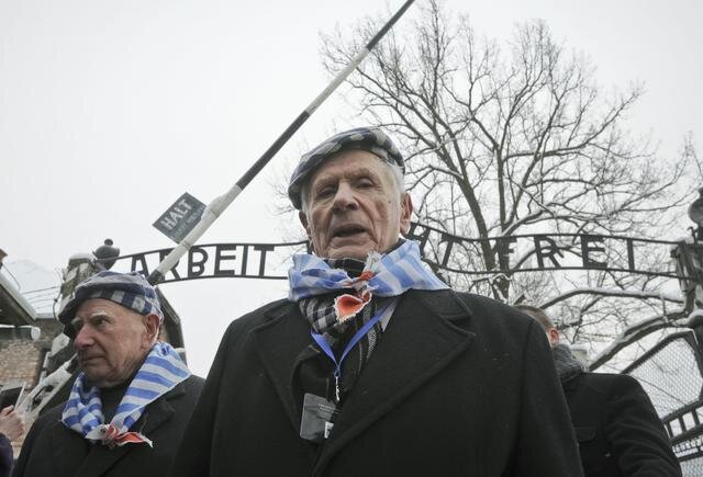 Az auschwitzi túlélők – már látogatóként – ismét átlépik a hírhedt feliratú kaput (Fotó: Beta/AP)