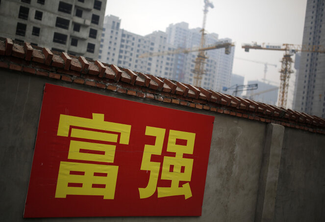 Jólétet és erőteljességet hirdető propagandafelirat egy kínai építkezés falán (Fotó: Beta/AP)