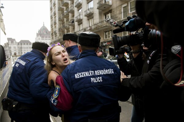 Rendőrök viszik el a Femen nőjogi szervezet félmeztelen aktivistáját az Országház közelében, az V. kerületi Balassi Bálint utca és Markó utca kereszteződésénél 2015. február 17-én. A nő „Putin go home!” (Menj haza Putyin!) feliratú ruhában demonstrált Vlagyimir Putyin orosz elnök érkezése előtt. (MTI Fotó: Koszticsák Szilárd)