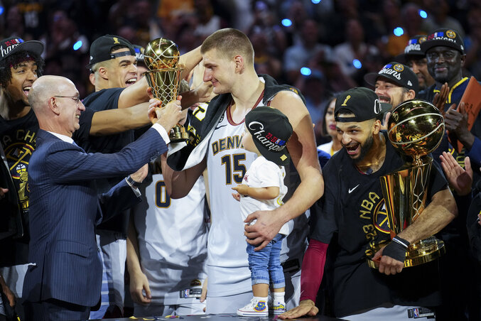 Jokić (és kislánya, Ognjena) átveszi Adam Silver NBA-vezértől a döntő MVP-jének járó Bill Russell-trófeát, mellette Murray a bajnoknak járó Larry O’Brien-trófeával (Fotó: Beta/AP) Jokić (és kislánya, Ognjena) átveszi Adam Silver NBA-vezértől a döntő MVP-jének járó Bill Russell-trófeát, mellette Murray a bajnoknak járó Larry O’Brien-trófeával (Fotó: Beta/AP)