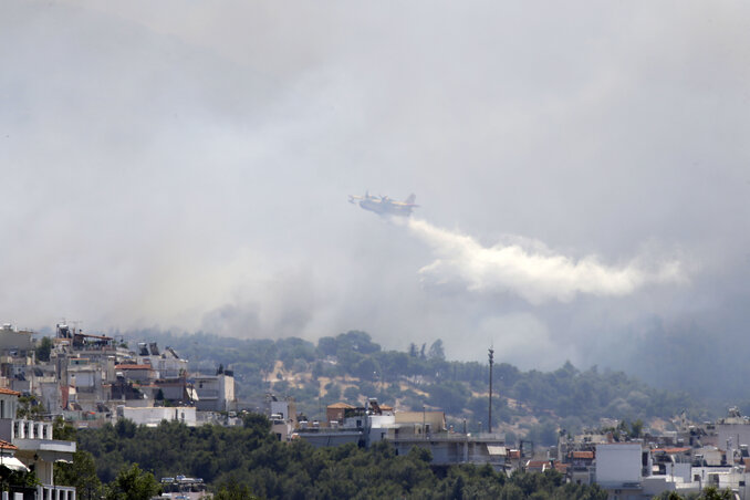 Egy tűzoltó repülőgép igyekszik Athénnál megfékezni a lángok terjedését (Fotó: Beta/AP)