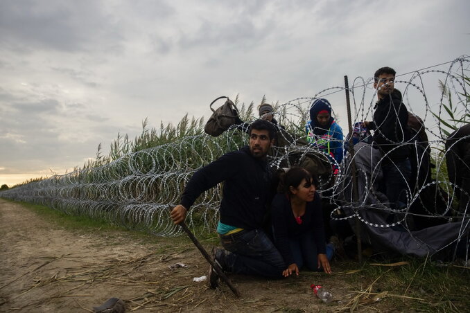 A drótakadályon átkelő illegális határátlépők (fotó: MTI)
