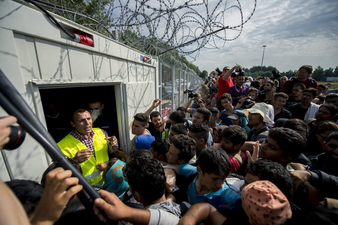 Élelmet osztanak a rendőrök a menekülteknek (fotó: MTI)