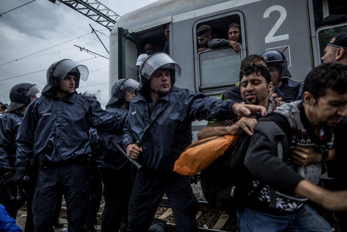 A horvát rendőrök a vonatra szálló migránsokat próbálják irányítani (Fotó: Beta/AP)