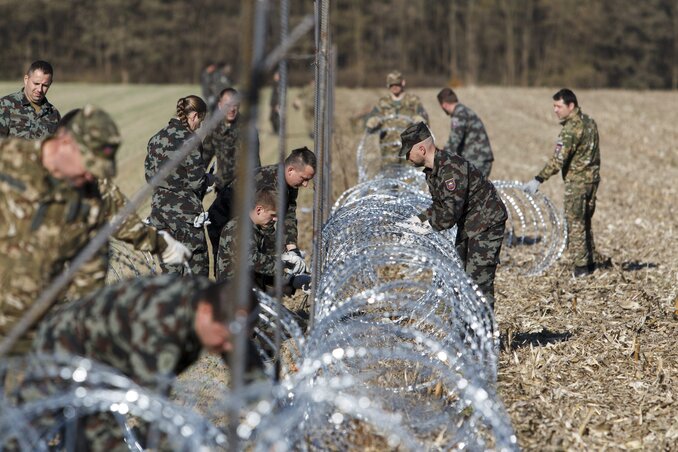 Szlovén katonák NATO-drótból építenek kerítést a szlovéniai Murafüred és a horvátországi Hétház közötti határátkelőnél (Fotó: MTI)