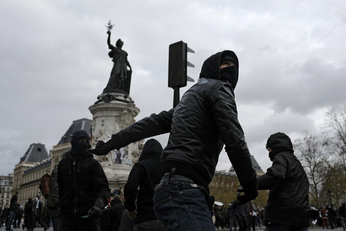 A feketébe öltözött, arcukat eltakaró tüntetők a rendőrökre támadnak a République téren (Fotó: Beta/AP)