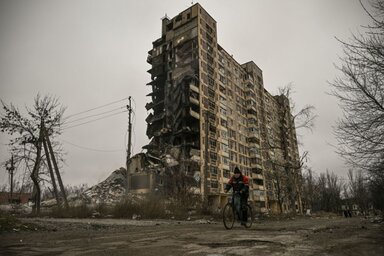 Kerékpározó férfi az orosz támadásokban súlyosan megrongált toronyháznál a Donyeck megyei Avgyijivkában (Fotó: AFP/Getty Images)