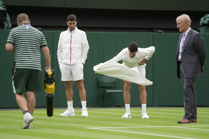 Novak Đoković a törölközőjével ellenőrizte a centerpálya füvének nedvességét, majd meggyőzte a főbírót a szünetről (Fotó: Beta/AP) Novak Đoković a törölközőjével ellenőrizte a centerpálya füvének nedvességét, majd meggyőzte a főbírót a szünetről (Fotó: Beta/AP)