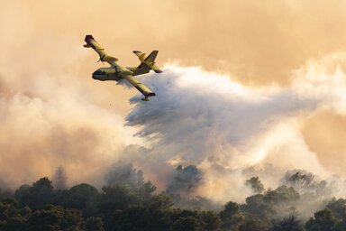 A firefighting plane sprays water to extinguish wildfire at Ciovo island, Croatia, Thursday, July 27, 2023. A large fire is reported on the island of Ciovo, close to Split on the Croatian Ad