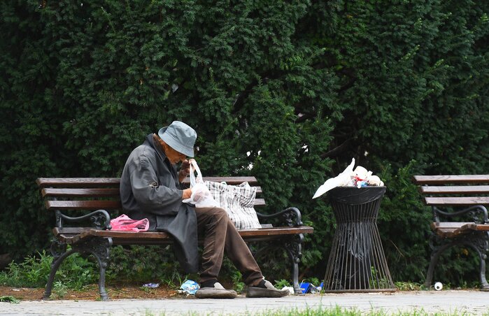 Novi Sad, 26.07.2023. - Beskucnik gleda svoje stvari dok sedi na klupi na novosadskom parku. (BETAPHOTO/DRAGAN GOJIC) Novi Sad, 26.07.2023. - Beskucnik gleda svoje stvari dok sedi na klupi na novosadskom parku. (BETAPHOTO/DRAGAN GOJIC)
