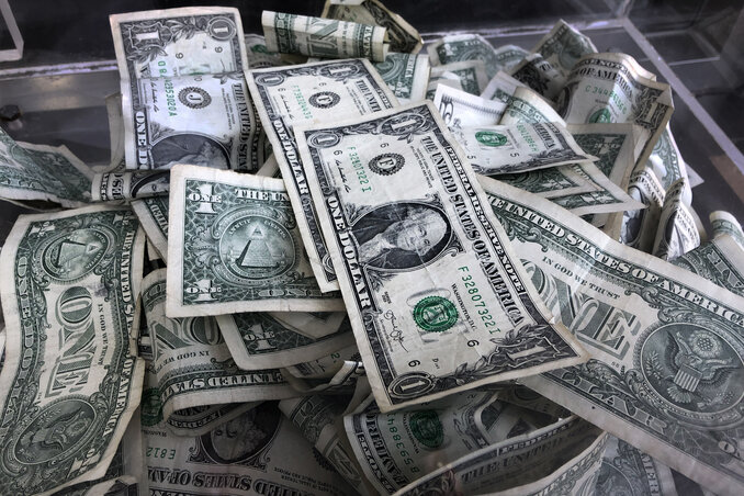 FILE - In this April 3, 2019, file photo a tip box is filled with U.S. currency in New York. Deciding how to prioritize different savings goals can be overwhelming, but financial experts rec FILE - In this April 3, 2019, file photo a tip box is filled with U.S. currency in New York. Deciding how to prioritize different savings goals can be overwhelming, but financial experts rec