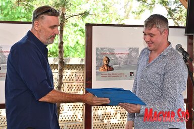 A novellapályázat idei győztese, Riegel Zoltán átveszi a díjat Molnár Róberttől, a zsűri tagjától