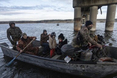 Ukránok egy lebombázott híd lábazatánál eveznek a kelet-ukrajnai Harkiv megyében levő Sztarji-Szaltiv településnél (Archív fotó: MTI/AP)