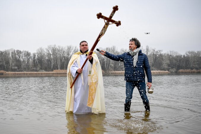 Czókoly Sándor káplán megáldja a Tisza-tavat mellette Ljasuk Dimitry, az esemény szervezője. Fotó: MTI/Czeglédi Zsolt