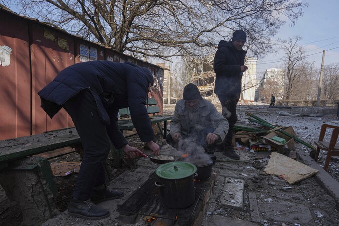 Mivel Mariupolban áram és csapvíz már legalább egy hete nincs, az emberek rögtönzött tűzhelyeken, a szabadban főznek (Fotó: AP via Beta)