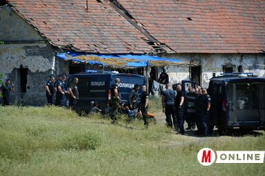 A gazdasági épület előtt a rendőrök körbe vették a  migránsokat (Fotó: Molnár Edvárd felvétele)