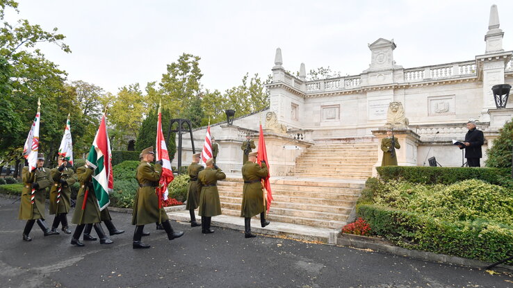 A díszegység tagjai történelmi zászlókkal vonulnak a Batthyány-mauzóleumnál (Fotó: MTI)