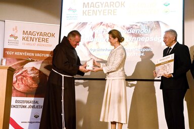 Böjte Csaba, a Dévai Szent Ferenc Alapítvány alapítója átveszi az alapítvány javára felajánlott búzát Herczegh Anitától (Fotó: MTI)