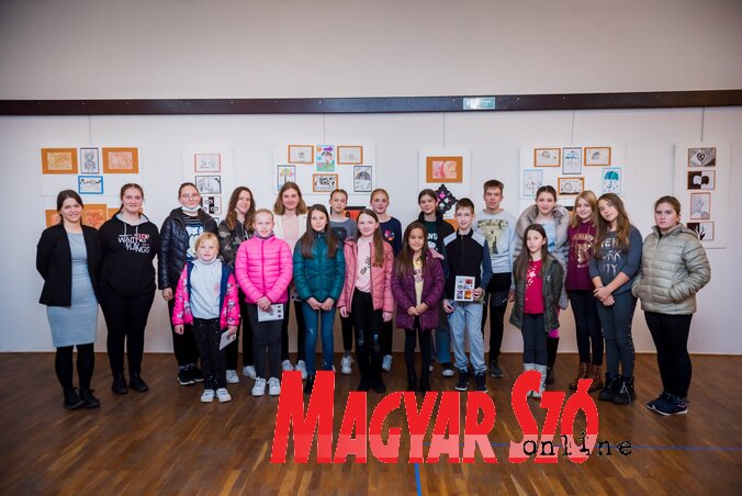 A Szivárvány Kuckó tagjai és tanárnőjük az őszi kiállítás képei előtt (Fotó: Sörfőző Kornél felvétele) A Szivárvány Kuckó tagjai és tanárnőjük az őszi kiállítás képei előtt (Fotó: Sörfőző Kornél felvétele)