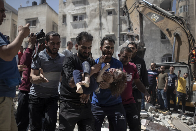 A légitámadás egyik gázai gyerekáldozatát viszik a palesztin férfiak (Fotó: Beta/AP)