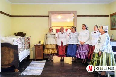 A régi, restaurált bácskossuthfalvi ágyon kiállított, kun hímzéssel készült párnavégek és a rendezvényen közreműködő Rezeda asszonykórus