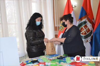 Savka Lazić (jobbról), a Ruka spasa egyesület elnöke átadja az ajándékot az egyik kismamának (Paraczky László felvétele)