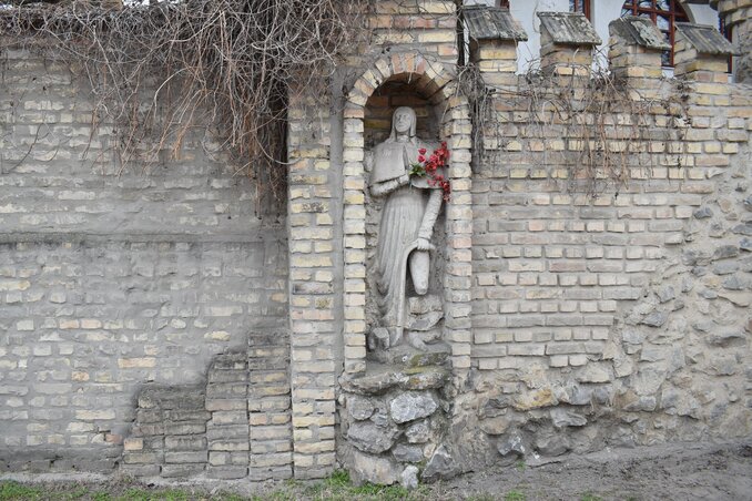 Rókus szobra a Szent Kereszt templom kerítésébe beépítve