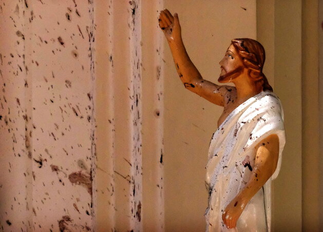 Vérnyomok a negombói katolikus templom falán és a Jézus-szobron (fotó: Beta/AP)
