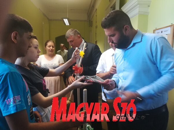 A BUM aktivistái az ülés előtt söprűk osztogatásával ösztönözték a képviselőket a dokumentum elfogadására (Fehér Rózsa felvétele)