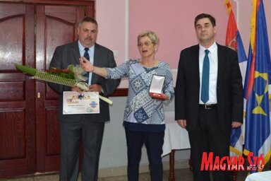 Nagy Juhász Klára, a bácskossuthfalvi Nyugdíjas Egyesület elnök asszonya átveszi a falu tanácsának a 70. jubileum alkalmából megítélt elismerését (Kazinczy Paszterkó Diana felvétele)